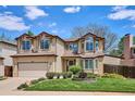 Charming two-story home with manicured lawn, mature landscaping, and neutral color palette at 7354 S Robb St, Littleton, CO 80127
