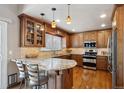 Gourmet kitchen with stainless steel appliances, granite countertops, and custom cabinetry at 7354 S Robb St, Littleton, CO 80127