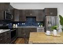 Modern kitchen featuring stainless steel appliances, dark cabinets, and a contrasting backsplash at 2857 S Pancratia St, Denver, CO 80236