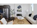Bright living room with fireplace, comfortable seating, and view to the kitchen and dining area at 2857 S Pancratia St, Denver, CO 80236