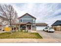 Inviting two-story home with a covered porch, spacious driveway, and attached garage for convenient parking at 1824 Asoka St, Strasburg, CO 80136