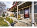 Charming front porch with seating, decorative plants, and inviting entrance to this lovely home at 1824 Asoka St, Strasburg, CO 80136