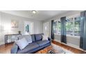 Bright living room featuring a gray sofa with decorative pillows and a large window for ample natural light at 1137 Colorado Blvd, Denver, CO 80206