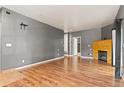 Open living area with hardwood floors, a fireplace, and access to other rooms at 8055 W Eastman Pl # 104, Lakewood, CO 80227
