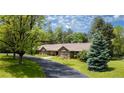 Well-maintained brick ranch home with mature trees, a long driveway, and pristine landscaping at 39 Sedgwick Dr, Cherry Hills Village, CO 80113