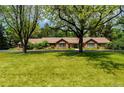 Spacious single-story home with a well-manicured lawn and mature trees, providing shade and curb appeal at 39 Sedgwick Dr, Cherry Hills Village, CO 80113