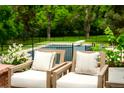 Inviting outdoor seating area with comfortable chairs and a view of the pool and lush greenery at 39 Sedgwick Dr, Cherry Hills Village, CO 80113