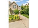 Lovely stone home featuring lush landscaping, a verdant lawn, and a inviting walkway at 421 Saint Paul St, Denver, CO 80206