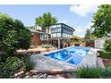 Backyard view featuring a sparkling blue pool, surrounded by a patio and lush landscaping at 10520 W 101St Pl, Westminster, CO 80021
