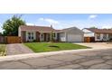 Inviting single-Gathering home featuring a lush green lawn, mature tree, and an attached garage at 11323 Albion St, Thornton, CO 80233