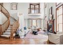 Bright living room with vaulted ceilings, fireplace, and staircase with wood accents at 10260 Longview Dr, Lone Tree, CO 80124