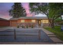 Charming single-story home showcasing a stone facade, orange trim, and well-maintained landscaping at 3107 S Wolff St, Denver, CO 80236