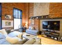 Inviting living area featuring exposed brick, comfortable seating, and a media center, creating a cozy atmosphere at 1450 Wynkoop St # 3F, Denver, CO 80202