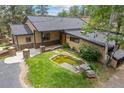 Charming home with stone accents, inviting front porch, and a lovely pond in the front yard at 32173 Soda Creek Dr, Evergreen, CO 80439