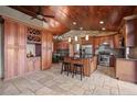 Custom kitchen with a stone backsplash, wine rack, a large central island, and plenty of cabinet space at 32173 Soda Creek Dr, Evergreen, CO 80439