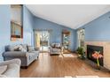 Inviting living room featuring a fireplace, hardwood flooring, vaulted ceilings, and a sliding glass door at 3545 W 132Nd Pl, Broomfield, CO 80020