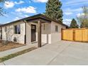 Modern home with a stucco exterior, wood accents, and a gated driveway for added privacy at 3210 Newport St, Denver, CO 80207