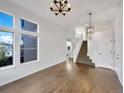 Bright entryway featuring wood floors, large windows, a modern chandelier, and staircase to the second floor at 4901 Yates Ct, Broomfield, CO 80020