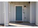 Charming home exterior with a blue front door, white pillars, and modern lighting fixture at 3015 Pershing St, Strasburg, CO 80136