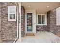 Covered front porch seating area featuring stone pillars at 17039 E Exposition Dr, Aurora, CO 80017