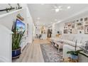 Open-concept living room with light wood floors and bright white walls with gallery wall at 17039 E Exposition Dr, Aurora, CO 80017
