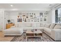 Cozy living room featuring a large comfortable sectional couch and unique gallery wall at 17039 E Exposition Dr, Aurora, CO 80017