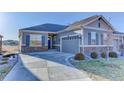 Beautiful single-story home with a well-manicured lawn, stone accents, and spacious concrete driveway at 12668 Ulster St, Thornton, CO 80602