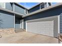 Two-car garage and entry of charming townhome with stone accents at 281 Rockview Dr, Superior, CO 80027