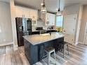 Modern kitchen boasts an island with seating, stainless steel appliances, and stylish two-tone cabinets at 1732 Stable View Dr, Castle Pines, CO 80108