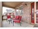 Covered porch with red seating and a red door entrance at 444 N Jamestown Way, Aurora, CO 80018