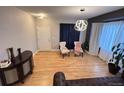 Bright living room with hardwood floors, elegant light fixture, and comfortable seating arrangement at 12196 Helena St, Commerce City, CO 80603