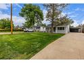 Curb view of a well-kept home with a large front yard, driveway, and mature trees at 7752 Meade St, Westminster, CO 80030