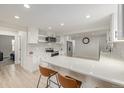 Bright, modern kitchen boasts an island with seating, stainless steel appliances, and white cabinets at 7752 Meade St, Westminster, CO 80030