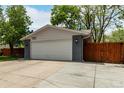 Charming home featuring an attached two-car garage, a driveway, and a well-maintained front yard with mature trees at 4643 S Vrain St, Denver, CO 80236