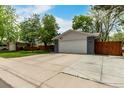Charming home featuring an attached two-car garage, a driveway, and a well-maintained front yard with mature trees at 4643 S Vrain St, Denver, CO 80236