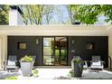 Stylish home entrance with black-framed glass doors, wood-paneled walls, and decorative planters with flower accents at 3355 E Eastman Ave, Denver, CO 80210