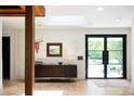 Inviting foyer with white brick walls, skylight, modern console table, and black-framed glass doors to the outside at 3355 E Eastman Ave, Denver, CO 80210