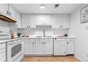 Clean, all-white kitchen with modern appliances, ample counter space, and a functional layout at 12780 Elm St, Thornton, CO 80241