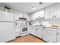 Functional kitchen featuring full-sized white appliances, maximizing space and ensuring a comfortable cooking environment at 12780 Elm St, Thornton, CO 80241