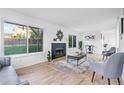 Bright living room with a cozy fireplace, large windows offering outdoor views, and modern decor at 12780 Elm St, Thornton, CO 80241