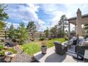 Outdoor living space showcasing a stone water feature, covered patio, and lush landscaping at 23742 E Calhoun Ave, Aurora, CO 80016