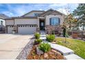 Beautiful two-story home featuring stone accents, manicured landscaping, and a spacious driveway at 23742 E Calhoun Ave, Aurora, CO 80016