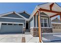 Charming home featuring a stone-accented porch, blue siding, and a well-manicured, low maintenance landscape at 11494 Colony Loop, Parker, CO 80138