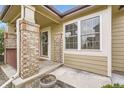 Inviting covered porch with brick columns and decorative wreath at 6132 Terry Ct, Arvada, CO 80403