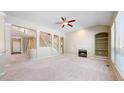 Spacious living room featuring a fireplace, built-in shelves, and a staircase with decorative columns at 9845 Keenan St, Highlands Ranch, CO 80130