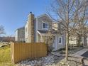 Gray house with stone chimney and fenced backyard at 11612 E Cornell Cir, Aurora, CO 80014