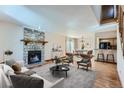 Inviting living room features a stone fireplace, hardwood floors and an open layout for easy entertaining at 11612 E Cornell Cir, Aurora, CO 80014