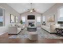 Bright living room featuring vaulted ceilings, a fireplace, and large windows for natural light at 12953 Bridge View Ln, Parker, CO 80134