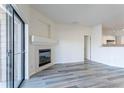 Living room view showcasing a fireplace, sliding door, and an open concept kitchen at 7414 S Alkire St # 101, Littleton, CO 80127