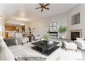 Open living room with a fireplace, neutral decor, and a view to the kitchen and dining area at 6000 W Floyd Ave # 116, Denver, CO 80227